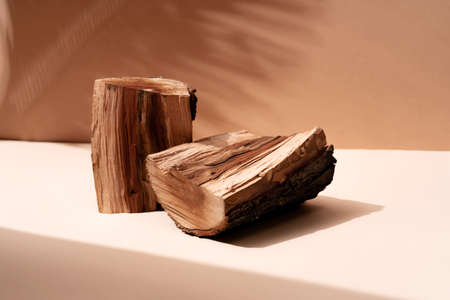 Natural wood podium with tropical leaves shadow in the background. Beautiful background from natural...