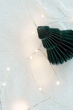 Fashionable eco-friendly Christmas tree toys made of paper, New Years garland on a lamb wool fabric...