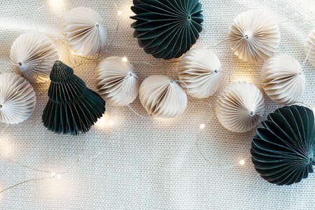 Fashionable eco-friendly Christmas tree toys made of paper, New Years garland on a lamb wool fabric background. Eco friendly Christmas background.の写真素材