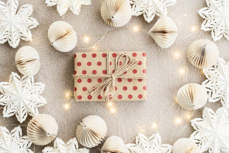 Beige paper gift boxes on a beige carpet lights Christmas garland and Christmas decorations made of...