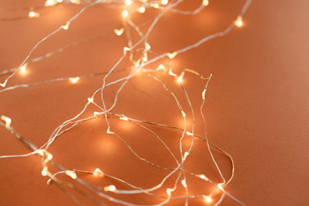 Defocused orange background. Festive Christmas background from a glowing garland with many lights....