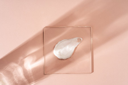 Smears of various skin care cosmetics are spread on glass on a pastel beige background. Cosmetic background.の写真素材
