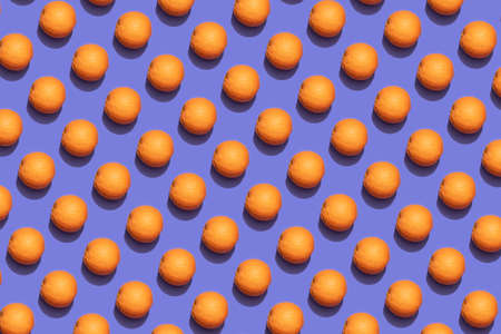 Fruit oranges in checkered pattern on violet background. Violet and orange colors background from fruity oranges. Demonstrating very peri, color of 2022 year.の写真素材