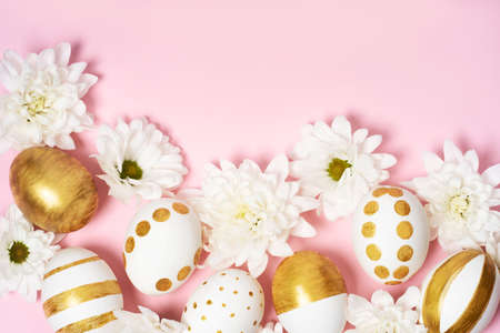 Hand-drawn easter eggs and spring white flowers on pink pastel background. Many easter eggs flat lay background.の写真素材