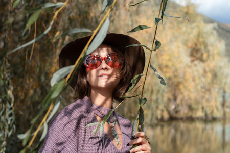 Woman resting in nature smiles and looks to the future with a beautiful view of the forest. The concept of relaxation and meditation unity with natureの写真素材