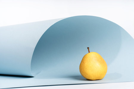 Podium for exhibitions and product presentations, material: stone, fruit. Beautiful blue background with yellow pearls. Abstract minimal empty background composition for product presentationの写真素材