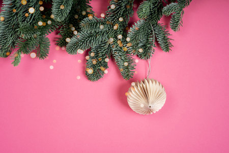 Festive Christmas background New Year's balls and garlands on a pink background. Different glasses for cocktails, drinks, long sun shadow festive background.の写真素材