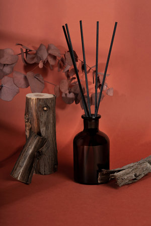 Beautiful diffuser bottle in brown glass jar on wood texture. Home decor, aromatherapy rest...