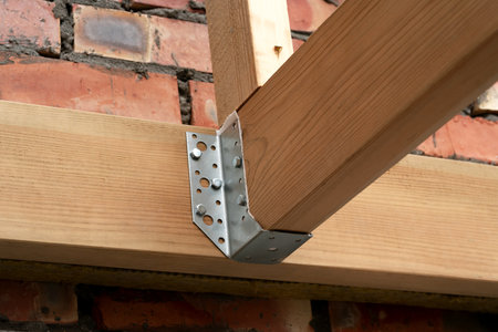 Making a wooden roof. Close-up wooden roof trusses in a frame structure. Steel beam connections....