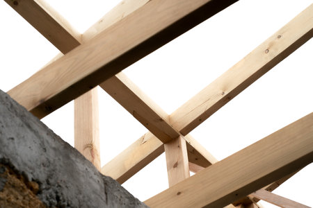Making a wooden roof. Close-up wooden roof trusses in a frame structure. Steel beam connections....