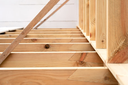 Making a wooden roof. Close-up wooden roof trusses in a frame structure. Steel beam connections. Wooden roof structureの写真素材