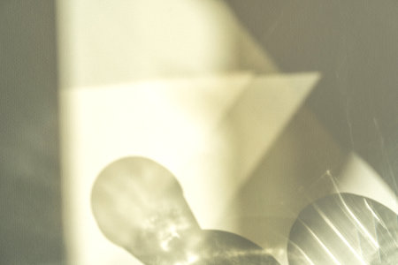 Different glasses for wine, cocktails, drinks, long sun shadow on a light beige background. The concept of summer vacationの写真素材