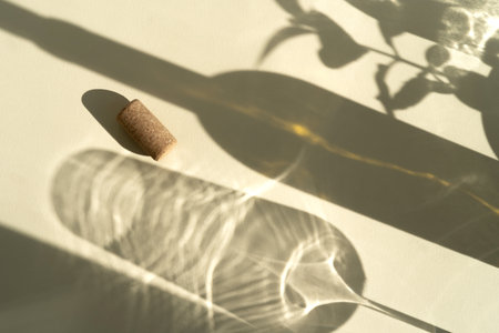 Different glasses for wine, cocktails, drinks, long sun shadow on a light beige background. The concept of wine tasting or summer vacationの写真素材