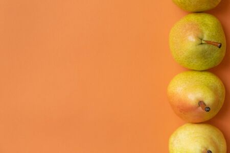 four pears on an orange backgroundの写真素材
