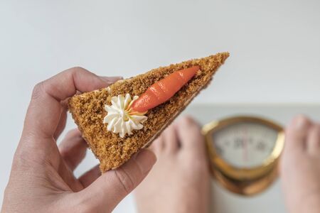 girl on the scales with a piece of cakeの写真素材
