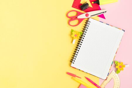 notebook and stationery on a yellow and pink backgroundの写真素材