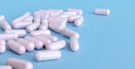pink pills scattered on a blue background
