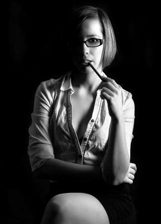 Young teacher in studio against dark backgroundの写真素材