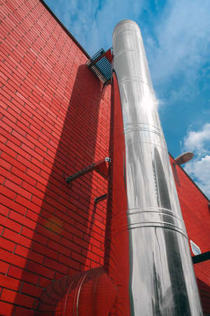 Red wall with big pipeの写真素材