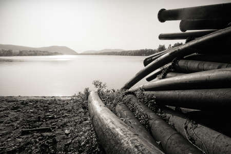 Large pipes running into the lake damaging the environmentの写真素材