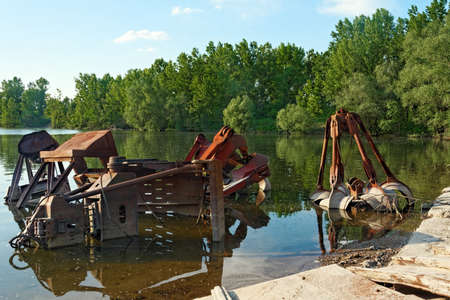 Large industrial machine on the shore of a lakeの写真素材