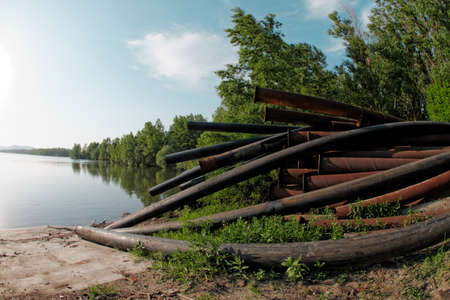 Large pipes running into the lake damaging the environmentの写真素材