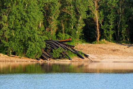 Pipes on the shore of the water outdoorsの写真素材