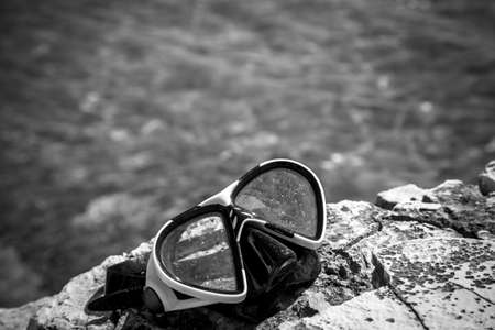 diving goggles on the beach with seaの写真素材