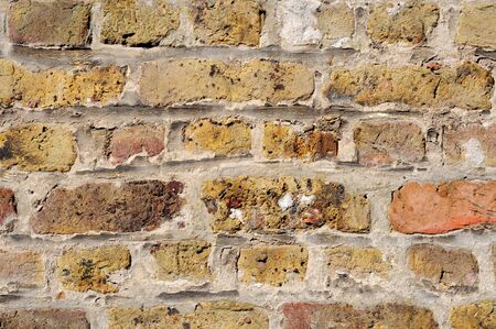 Old brick wall in shades of yellow, ochre, and brown, excellent background