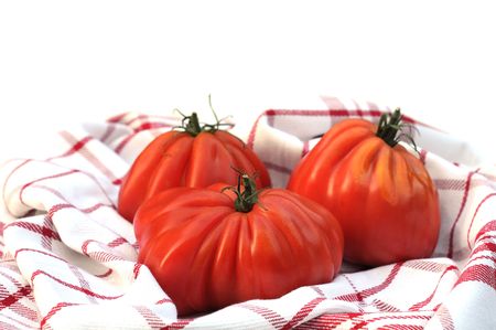 Oxheart tomatoes  in kitchen towelon white, shallow dofの写真素材