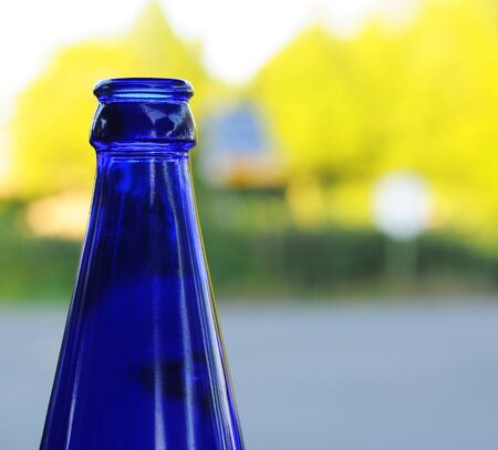 Blue bottle against colorful blurred background, copy spaceの写真素材