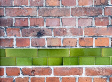 Old red brick wall with row of green enamel tiles, architectural backgroundの写真素材