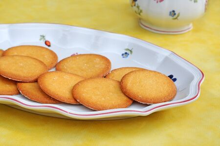 Butter biscuits or cookies on plate on yellow table-cloth, shallow dofの写真素材