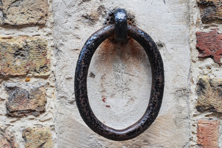 Metal, rusty ring in cement and pastel brick wallの写真素材