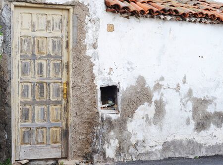 Old wooden door with brass doorhandle and rough wall with open water meter, Tenerife, copy spaceの写真素材