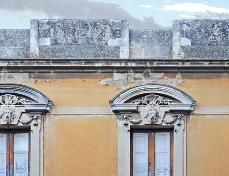 Detail of antique gable with stone faces in Brindisi, Italyの写真素材