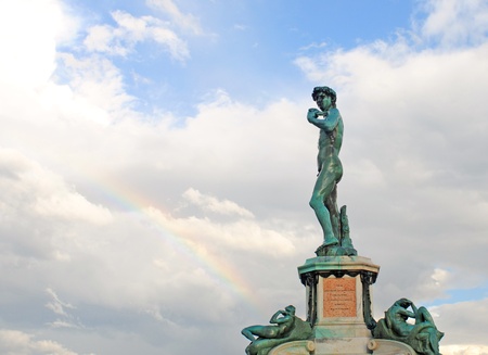 bronze statue of david with clouded sky and rainbow on piazzale michelangelo in firenze or florence, italy, europeの写真素材