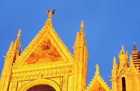 duomo or cathedral in siena, italy at golden hour against blue skyの写真素材