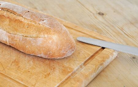 Italian bread on weathered wooden cutting board, selective focus