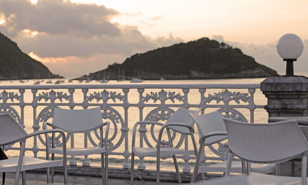 modern chairs by the antique wrought iron fence at the beach in San Sebastian, Basque country,...