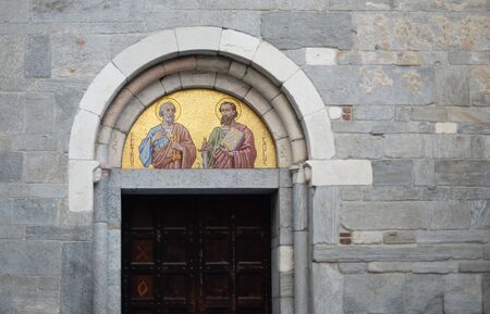 ancient luxury mosaic of saint peter and saint paul above old wooden door in the roman church of saint peter in gallarate, varese, italyの写真素材