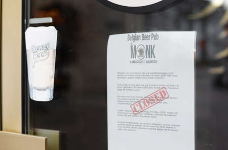BRUGES, BELGIUM â MARCH 15, 2020: Note in five languages on window of Belgian Beer Pub Monk about closure due to governmental measures against the rapid spread of the new coronavirus or COVID-19のeditorial素材