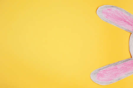 funny paper bunny ears on a yellow backgroundの写真素材