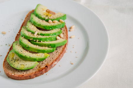 Healthy avocado toast with rye bread, sliced avocado,seeds, salt and pepper. Vegetarian food. Clean eating. Copy space.の写真素材