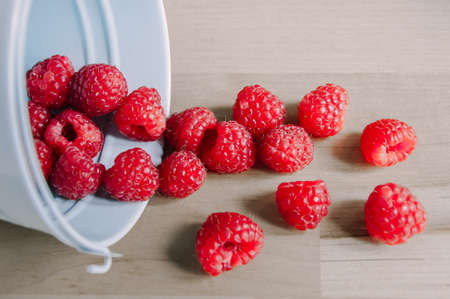 ripe and juicy raspberry in an inverted small bucketの写真素材
