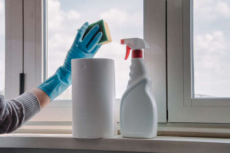 A set for cleaning windows. Hand in a blue glove. Cleaning tools and equipment.の写真素材