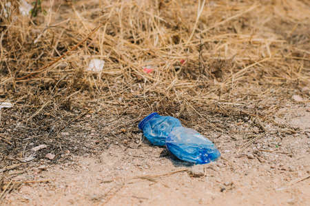 crumpled plastic bottle on the field, environmental pollution problemの写真素材