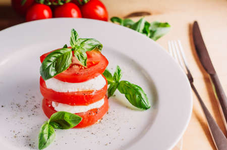 Caprese salad with mozarella cheese, tomatoes and basil.