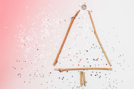 christmas tree made of sticks and decorations on a pink background.Flat lay,christmas card,top viewの写真素材