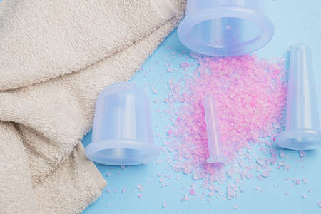 skin care and massage.Composition with Bath rose salt, massage vacuum jars on blu background.Spa and natural skin care conceptの写真素材